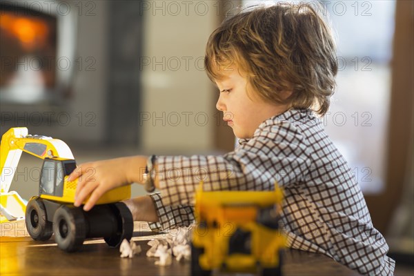 Caucasian boy playing with trucks