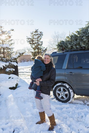 Caucasian mother holding son in snow