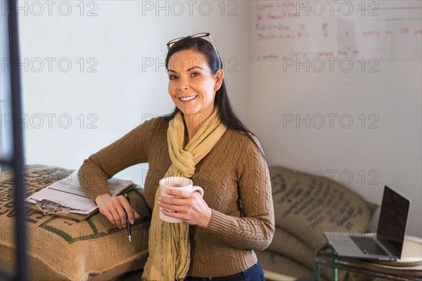 Hispanic business owner smiling in stock room