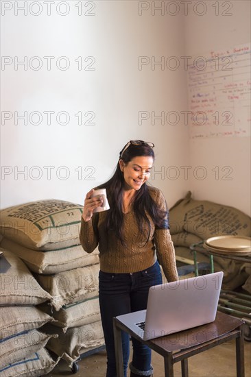 Hispanic business owner working in stock room