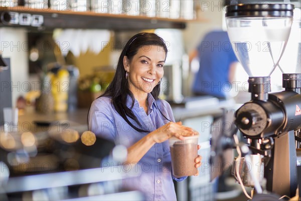 Hispanic barista making coffee in cafe