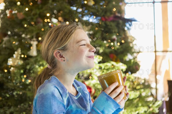 Caucasian girl drinking hot cocoa at Christmas