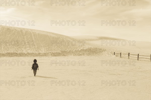Caucasian preschooler boy walking in desert