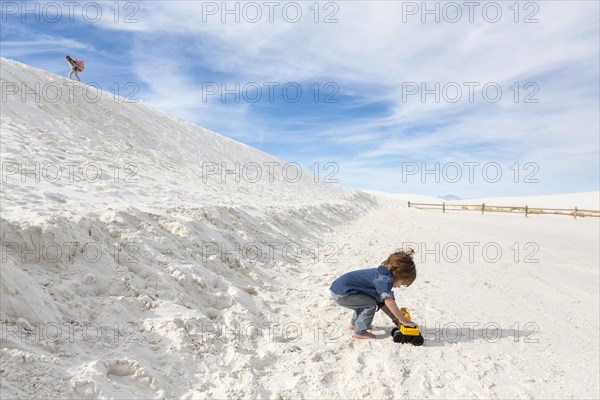 Caucasian boy playing with toy truck in desert