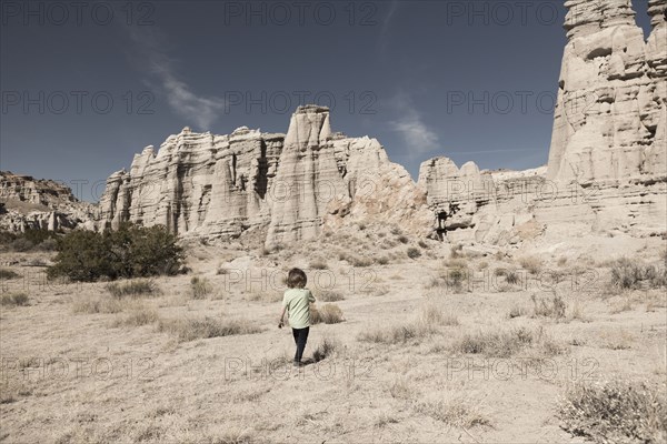 Caucasian preschooler boy walking in desert