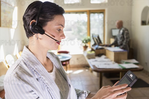 Businesswoman using digital tablet and headset in office