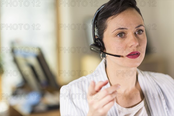 Businesswoman talking on headset in office