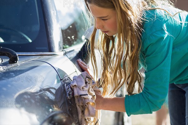 Caucasian girl washing car