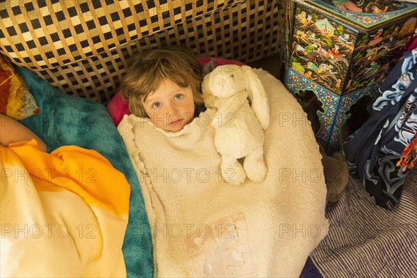 Caucasian boy laying in blanket pile