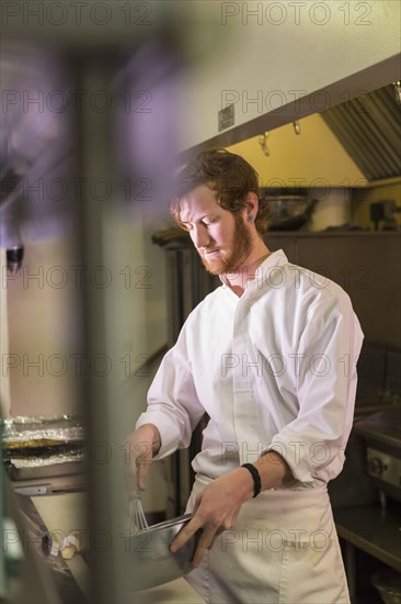 Caucasian chef reading orders in restaurant kitchen