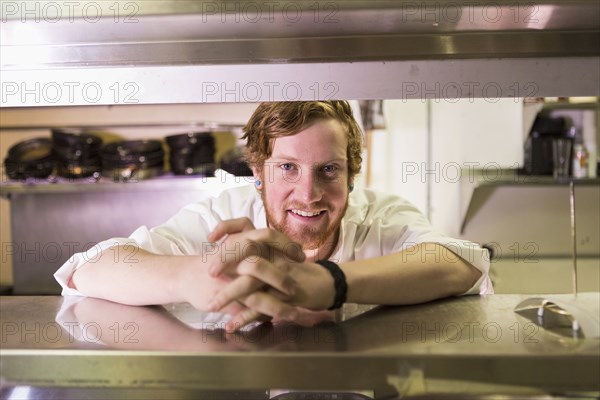 Caucasian chef smiling in restaurant kitchen