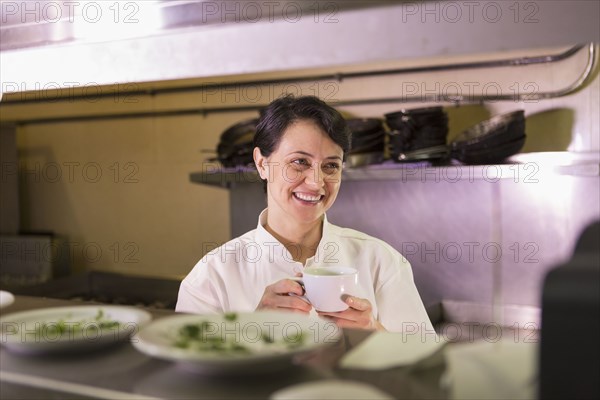 Caucasian chef smiling in restaurant kitchen