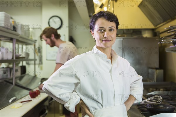Caucasian chef smiling in restaurant kitchen