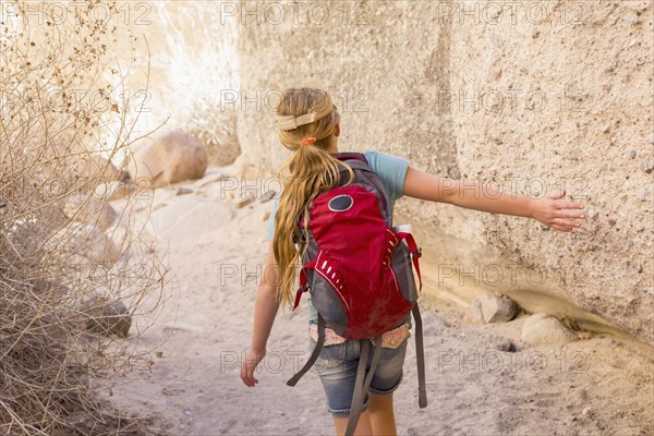 Caucasian girl touching rock formation