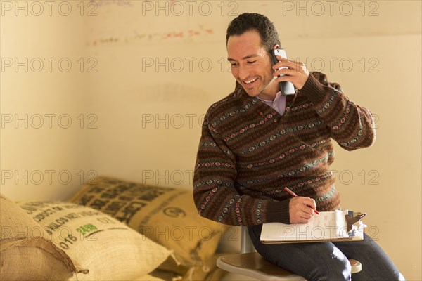 Hispanic entrepreneur talking on telephone in store