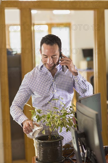 Hispanic businessman talking on telephone in office