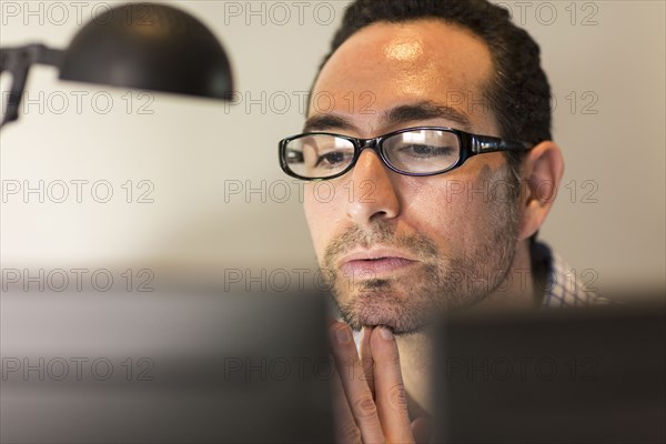 Hispanic businessman using computer in office