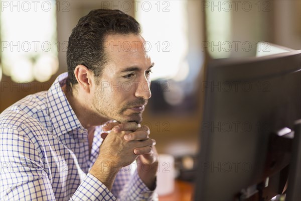 Hispanic businessman using computer in office