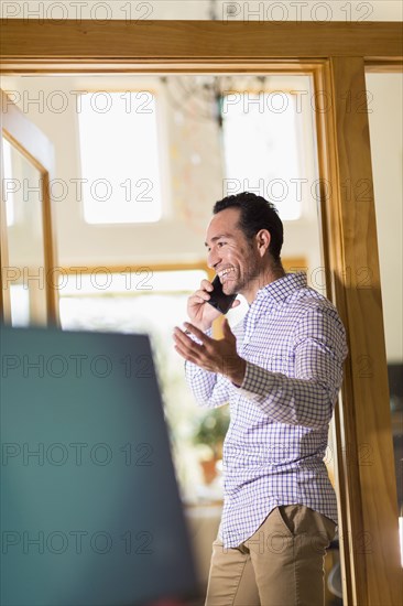 Hispanic businessman talking on telephone in office