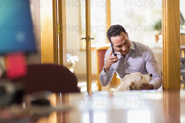 Hispanic businessman talking on telephone in office