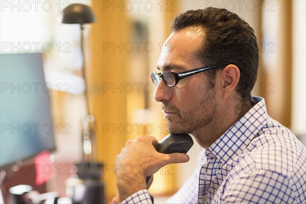 Hispanic businessman using computer in office