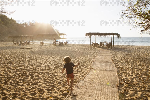 Caucasian boy following path to beach