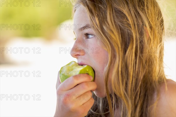 Caucasian girl eating green apple