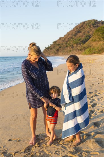 Caucasian family standing on beach