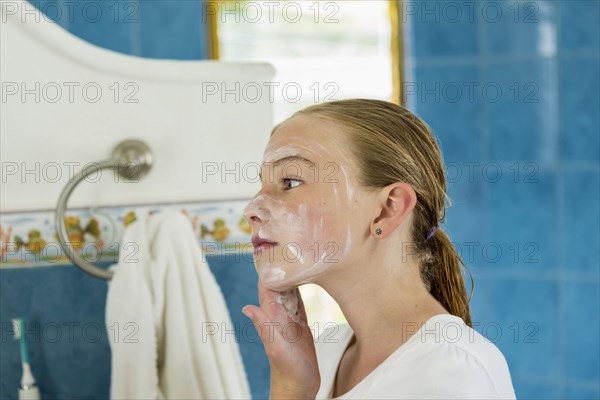 Caucasian girl washing face with soap