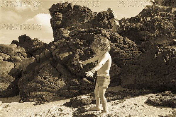 Caucasian brother and sister playing on beach