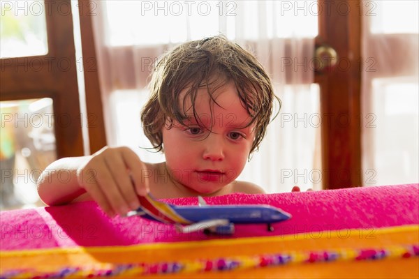 Caucasian boy playing with toy airplane
