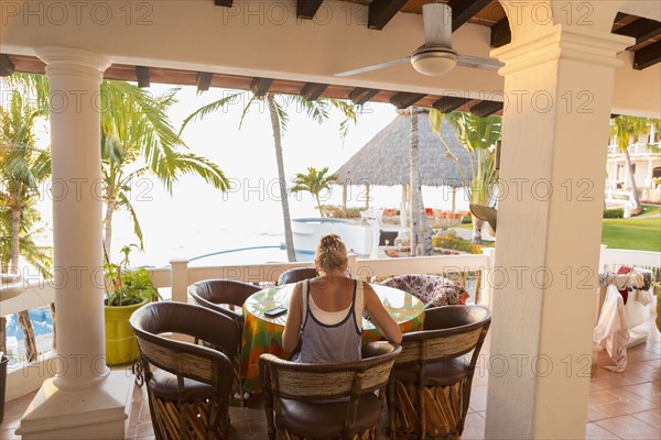 Caucasian woman sitting at waterfront table