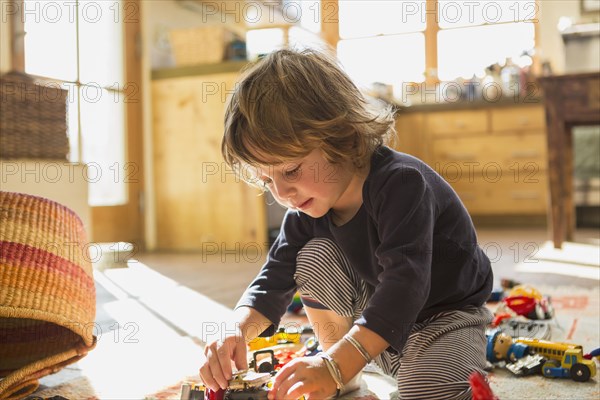 Caucasian boy playing with toys on floor