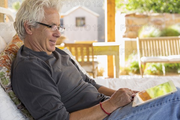 Caucasian man using digital tablet on patio