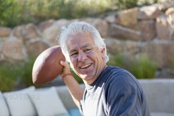 Caucasian man throwing football