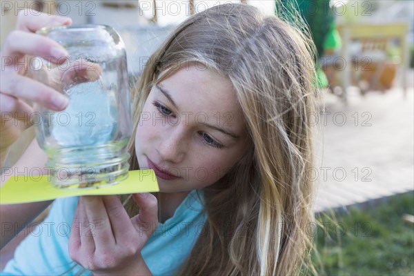 Caucasian girl examining insects in jar