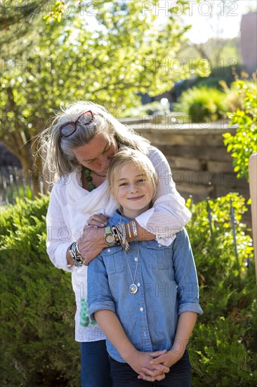 Smiling Caucasian grandmother hugging granddaughter