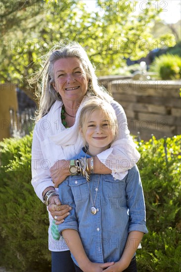 Smiling Caucasian grandmother hugging granddaughter