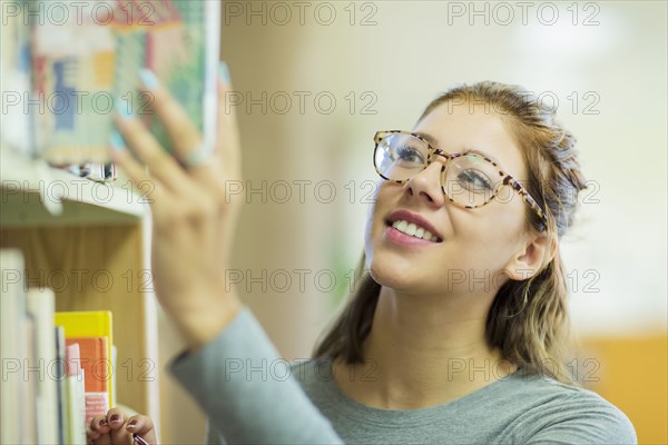 Mixed Race girl choosing book in library