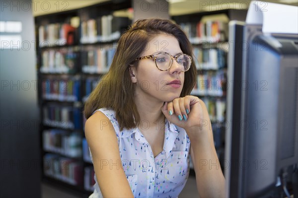 Mixed Race girl using computer in library