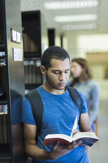 Mixed Race boy reading book in library