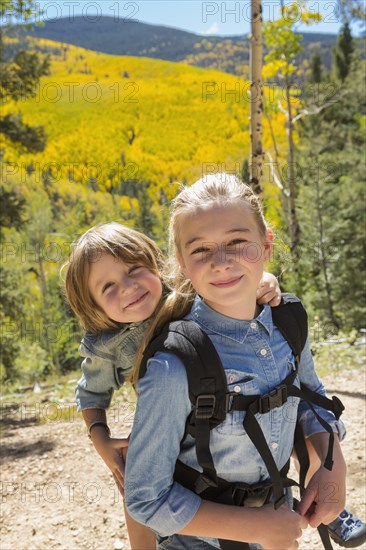 Caucasian girl carrying brother on back