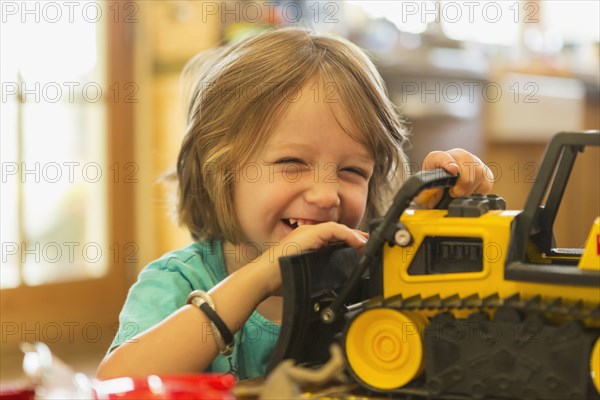 Portrait of Caucasian boy playing with toy bulldozer