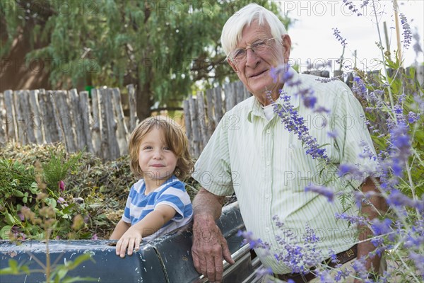 Portrait of smiling Caucasian grandfather and grandson at truck