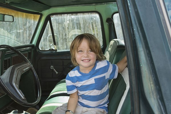 Caucasian boy sitting in truck