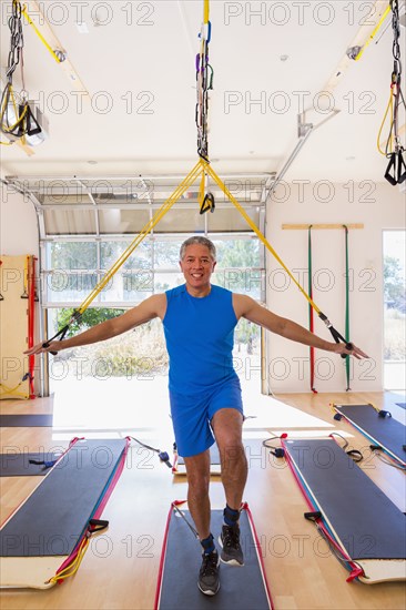 Mixed Race man using resistance bands in gymnasium