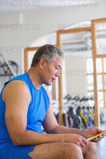 Mixed Race man reading notes in gymnasium