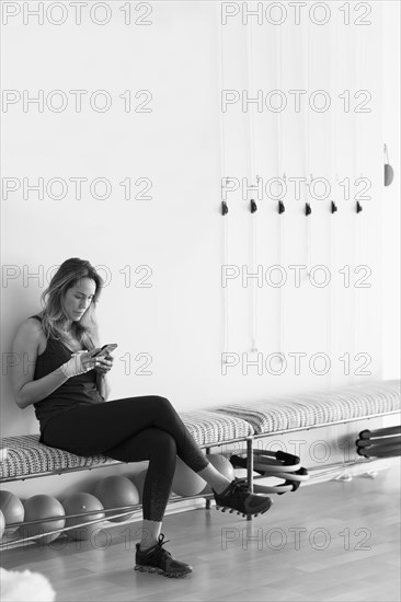 Caucasian woman texting on cell phone in gymnasium