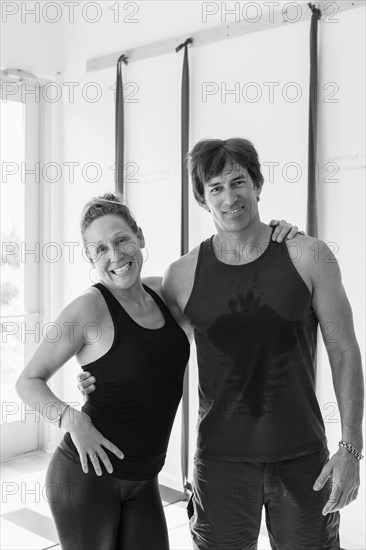 Portrait of smiling Caucasian couple hugging in gymnasium