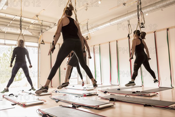 People lifting on handles in gymnasium